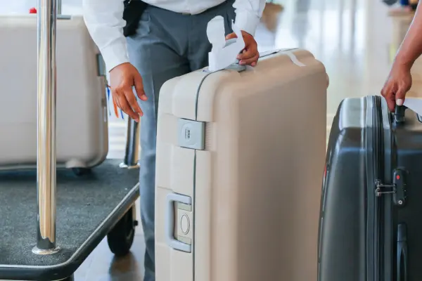 Bellboy membantu membawa koper tamu hotel