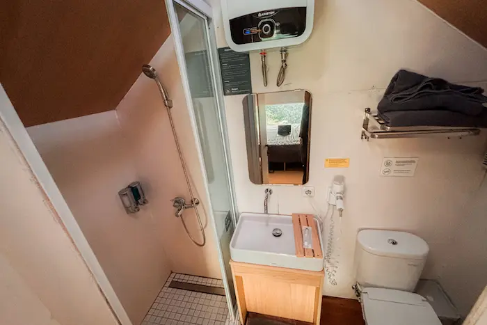 Toilet, shower dan water heater di dalam kamar mandi yang compact